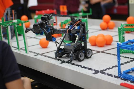 Vex Robot displayed upon table surrounded by different obstacles.