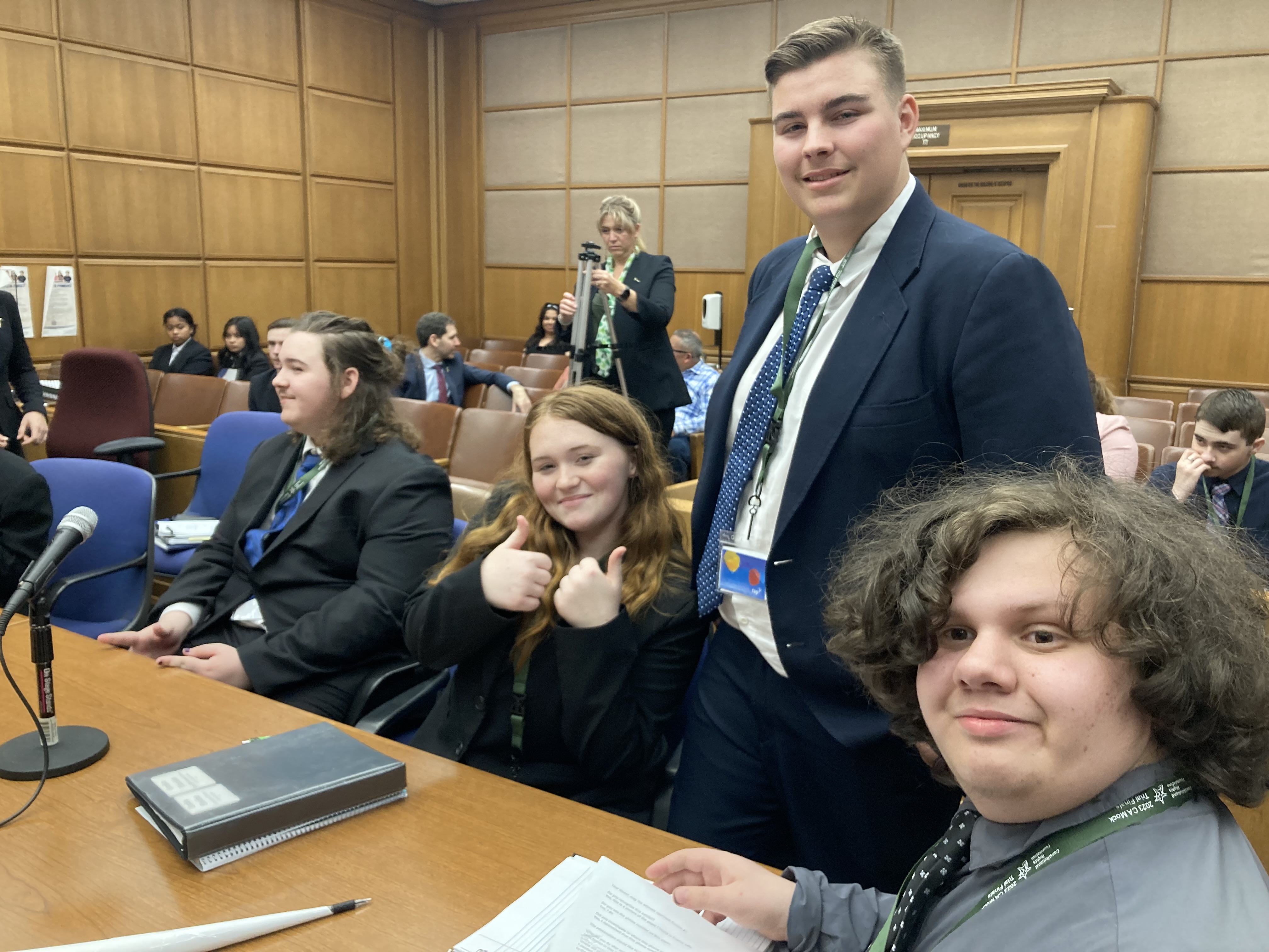 Mock trial students sitting at table smiling for picture